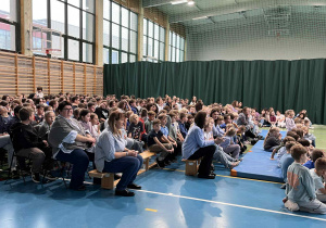uczniowie i nauczyciele podczas szkolnej akademii