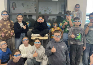 uczniowie pozują w papierowych niebieskich okularach, symbolizujących uważność, ciekawość i otwartość na prawa dziecka