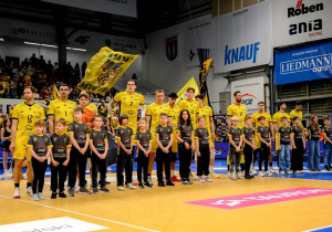 Uczniowie stojący w eskorcie wraz z zawodnikami Skry Bełchatów