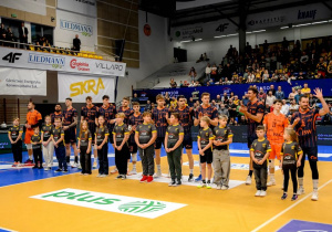 Uczniowie stojący w eskorcie wraz z zawodnikami Jastrzębskiego Węgla