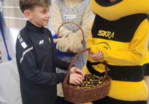 Uczeń wraz maskotką Skry i Galerii Bawełnianka