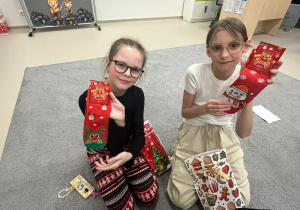 Dziewczynki prezentują prezenty od Mikołaja