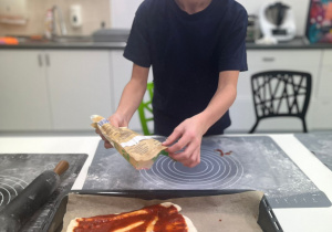 Uczeń przygotowuje pizzę