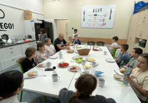 Uczniowie jedzą wspólnie śniadanie