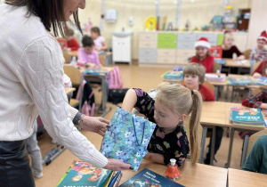 Pani dyrektor rozdaje cukierki uczniom