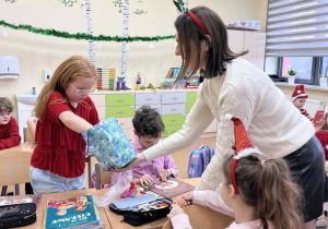 Pani dyrektor częstuje uczniów cukierkami