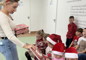 Nauczyciela rozdaje książki uczniom
