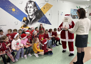 Pani dyrektor wraz z Mikołajem rozdają uczniom książki