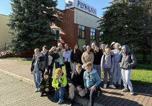 Uczniowie reprezentujący szkołę w zawodach stojący przed pływalnią