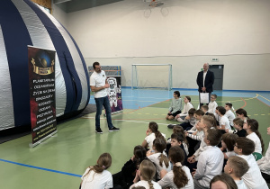 Uczniowie klas czwartych słuchają prelekcji o seansie