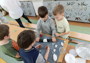 Uczniowie klasy 1b wałkują ceramiczną masę.