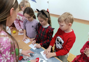 Uczniowie klasy 1b tworzą ozdoby świąteczne.