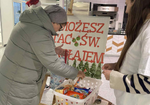 pani wrzuca do koszyka słodycze dla podopiecznych Domu Dziecka w Bełchatowie