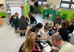 Podzielone na grupy dzieci z zaangażowaniem rozwiązują zagadki escape roomu.