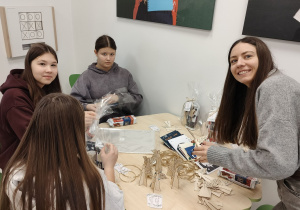 nauczyciel wraz z wolontariuszami pakuje świąteczne upominki dla podopiecznych DPS