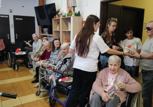 wolontariusz rozdaje podopiecznym świąteczne upominki