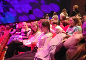 uczniowie siedzący na widowni