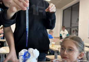 uczniowie wykonują doświadczenie "kolorowy deszcz"