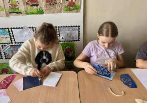 Dziewczynki tworzą kartki okolicznościowe.
