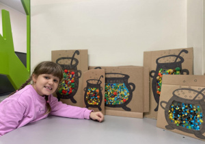 Uczennica pokazuje wykonane prace.