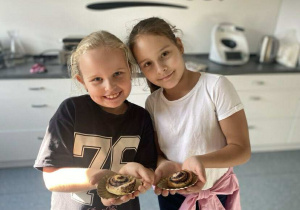 Dziewczynki prezentują swoje wypieki.