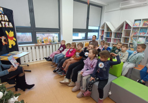 Bibliotekarka czyta tekst i pokazuje ilustracje z książki „Zimowe przygody”