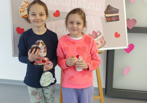 dziewczynki ze słodkościami pozują na tle dekoracji