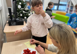 Uczennica delektuje się pomidorkami koktajlowymi