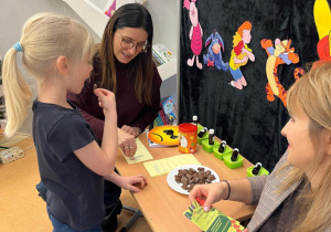 Uczennica próbuje czekolady, dobywając ostatnią pieczątkę i dyplom „Małego odkrywcy smaków”