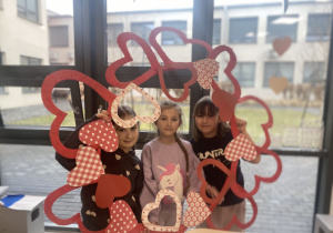 Uczniowie pozują przy serduszkowej fotobudce.