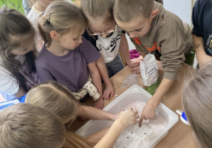 Uczniowie klas pierwszych bawią się walentynkową masą sensoryczną.