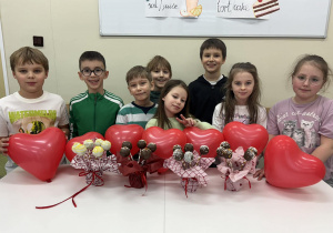 Uczniowie z dumą prezentują swoje walentynkowe słodkości.