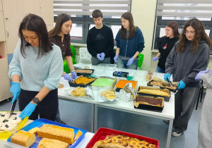 Wolontariusze kroją ciasto na akcję charytatywną