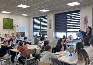 uczniowie i nauczyciele obserwujący słuchają informacji o Arktyce