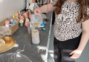 uczennica zalewa foremkę na świecę