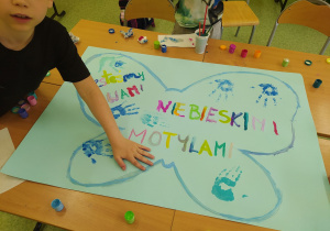 Chłopiec odbija dłoń na motylku