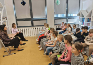 Uczniowie słuchają czytanej im bajki terapeutycznej