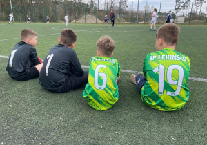 Chłopcy siedzący na boisku