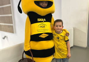 Uczeń pozujący z Pszczołą, maskotką klubową Skry