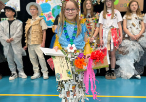 Uczennica klasy pierwszej w stroju z elementów przeznaczonych do recyklingu