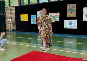 Uczennica klasy trzeciej w stroju z gazet