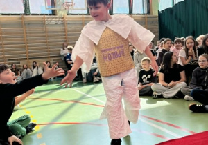 Uczeń klasy trzeciej w stroju z torebek papierowych