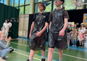 Chłopcy z klasy siódmej podczas prezentacji przygotowanych strojów z worów foliowych