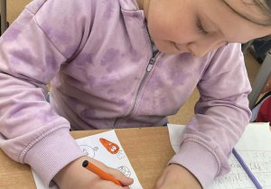 uczennica wykonuje zadanie z karty pracy