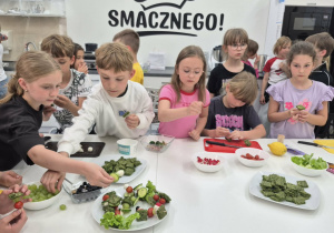 uczniowie tworzą owocowo warzywne koreczki