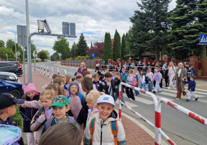 Liczna grupa uczniów wyrusza spod szkoły na wyprawę