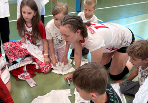 Uczniowie zbierający autografy od siatkarek