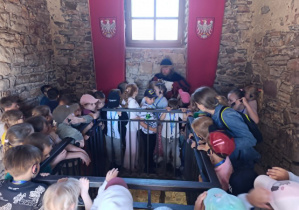 Dzieci z przewodnikiem w skarbcu zamku