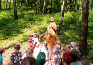 Uczniowie z przewodnikiem przed rzeźbą