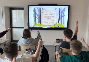 uczniowie pokazują kciuki z rozwiązanego prawidłowo escape room o pierścienicach